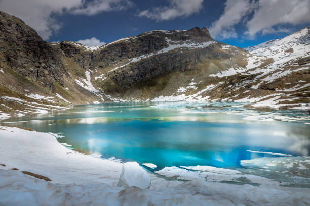 lago esmeralda alpino derretendo e montanhas na primavera, gran paradiso, itália - parque nacional de gran paradiso - fotografias e filmes do acervo