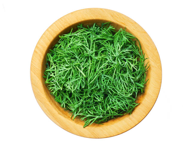 istock Fresh dill a wooden bowl isolated on a white background. Top view. 1423451820