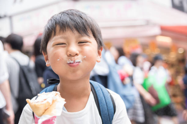 smiling japanese boy eating crepe