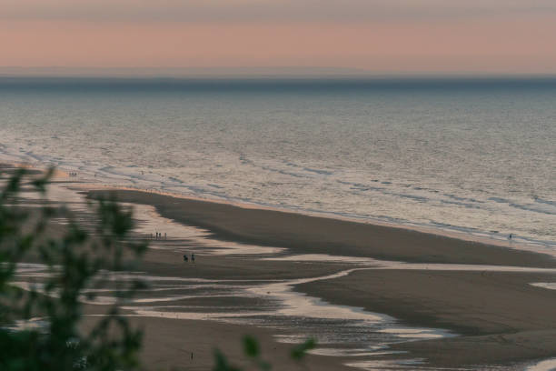 luz noturna atmosférica na praia de omaha, na costa atlântica francesa após o pôr do sol com silhueta de pessoas, colleville-sur-mer, normandia, frança - france sea allied forces atlantic ocean - fotografias e filmes do acervo