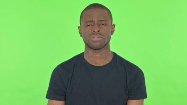 istock Sad Young African Man on Green Background 1423453631