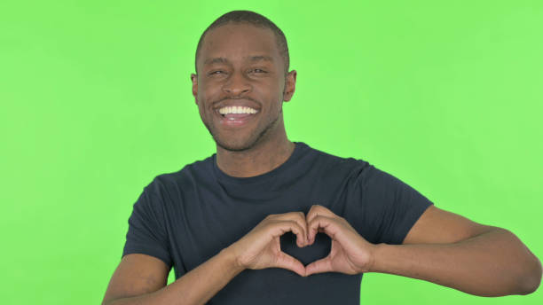 istock Handmade Heart by Young African Man on Green Background 1423455329