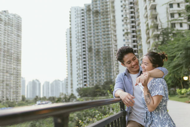 Home Ownership - Young adult Asian heterosexual couple celebrating the purchase of their new home Home Ownership - Young adult Asian heterosexual couple celebrating the purchase of their new home malay couple stock pictures, royalty-free photos & images