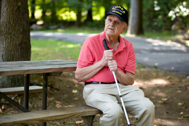 Blind Korean War Veteran sitting on park bench thinking