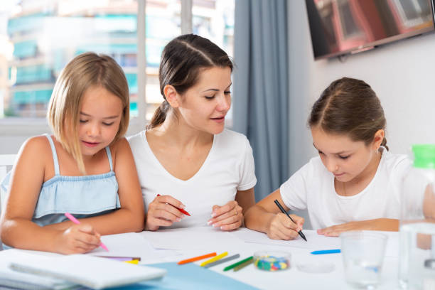 istock Young woman and two daughters drawing together 1423458279