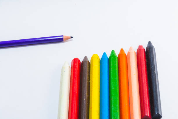 Colored wax and wooden pencils isolated on white background. Close up