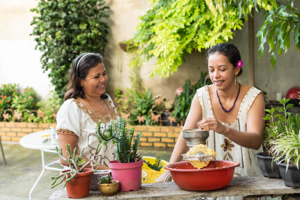 istock Two Women grinding corn for food Traditional 1423467282
