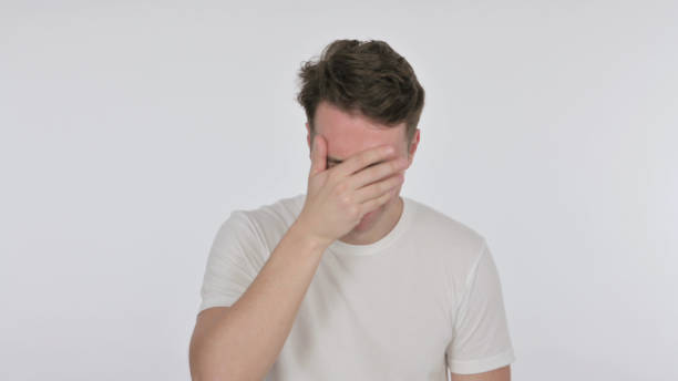 istock Disappointed Young Man Reacting Loss on White Background 1423469875