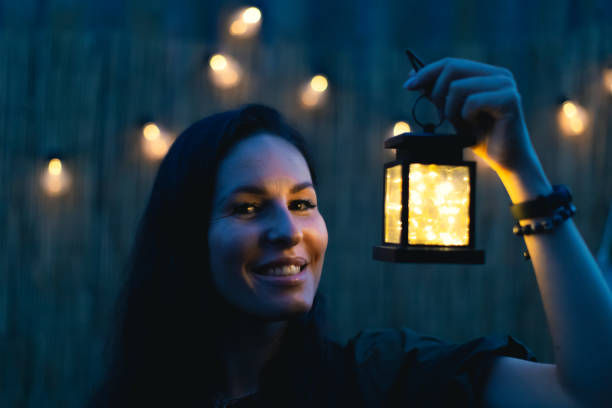 istock An attractive woman with a retro flashlight at dusk. 1423473560
