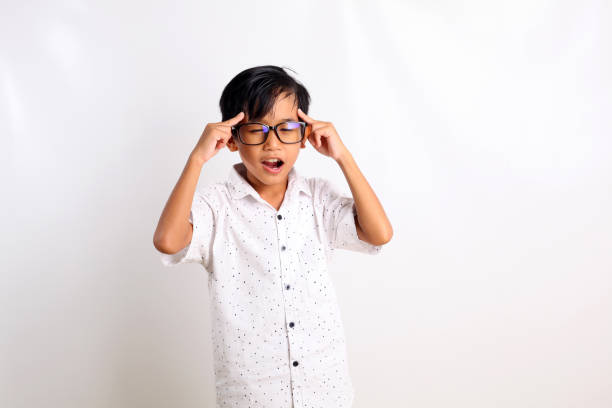 istock Smart asian boy standing while thinking and showing thinking gesture. Isolated on white background 1423477134