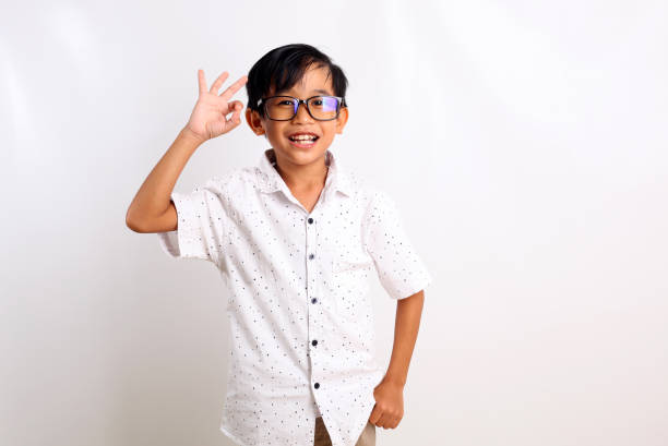 istock Happy asian boy standing while showing okay hand gesture. Isolated on white background 1423477277