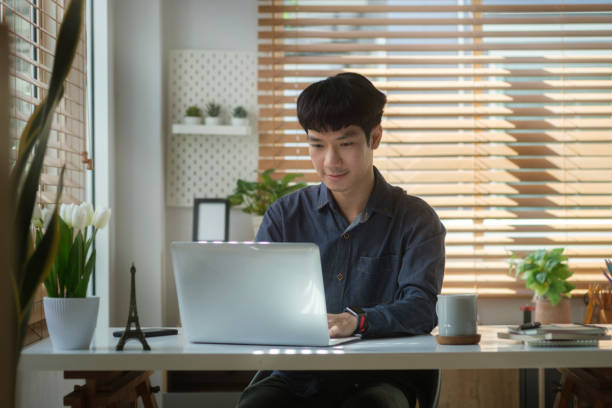 istock Asian man freelancer working online with computer tablet at home. 1423480943