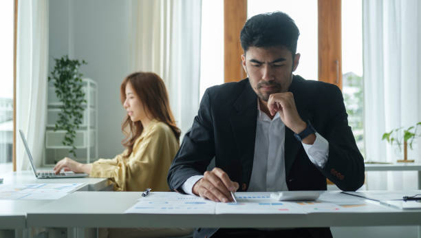 istock Concentrated businessman using calculator and analysing financial data at office desk. 1423481385