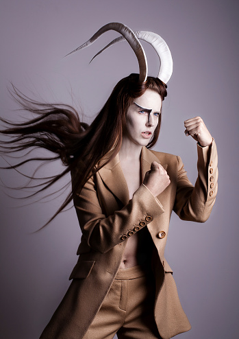 Female with horns in beige suit