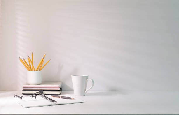 istock Comfortable workplace with coffee, stationery and houseplant on white table. 1423488289