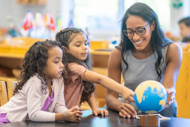 istock Montessori Teacher Looking at a Globe with Students 1423490812