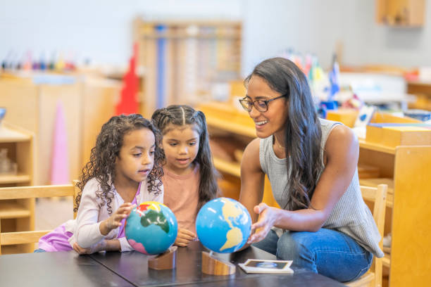 istock Montessori Teacher Looking at a Globe with Students 1423490815