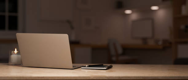 istock Modern office workspace at night close-up, laptop and copy space over blurred office background. 1423498291