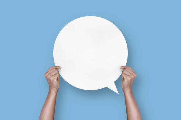 istock hand holding round white paper balloons speech bubbles isolated on light blue background 1423499283