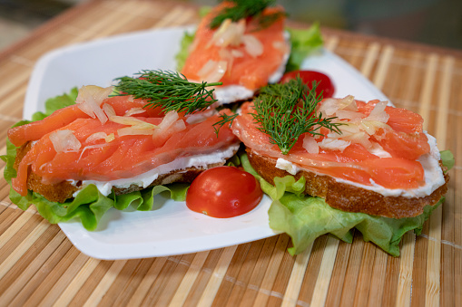 Canapes with salmon on brown background