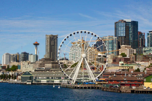 The Great Wheel On The Seattle Waterfront With The Space Needle In The Background The Great Wheel on the Seattle waterfront with the Space Needle in the far distance seattle ferris wheel stock pictures, royalty-free photos & images