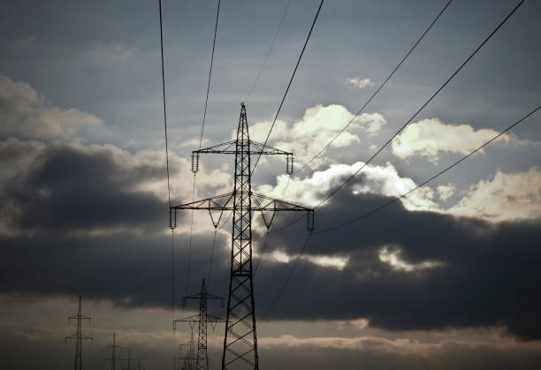 Something's brewing. High voltage pylons against a dramatic cloudy sky. stock photo