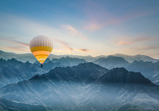 mongolfiera che sorvola le montagne rocciose in turchia - hot air balloon landscape sunrise mountain foto e immagini stock