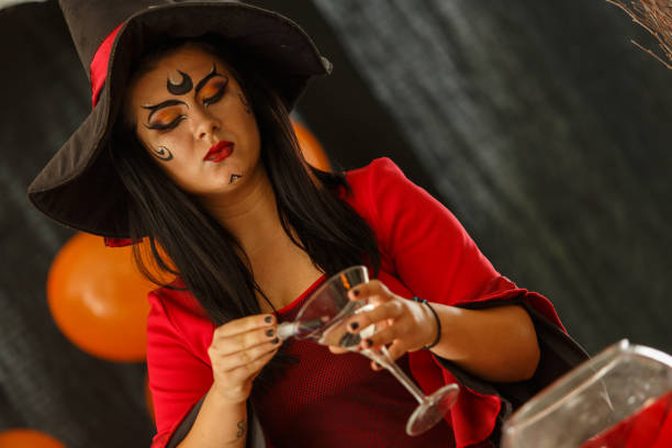 istock Witch adding a secret ingredient to the potion she is brewing 1423519641
