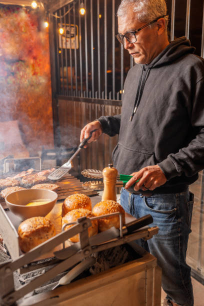 バーベキューでハンバーガーを準備する男 - barbecue grill barbecue burger hamburger ストックフォトと画像