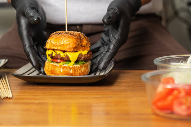 istock Cook plating a burger in the kitchen of a restaurant 1423522412