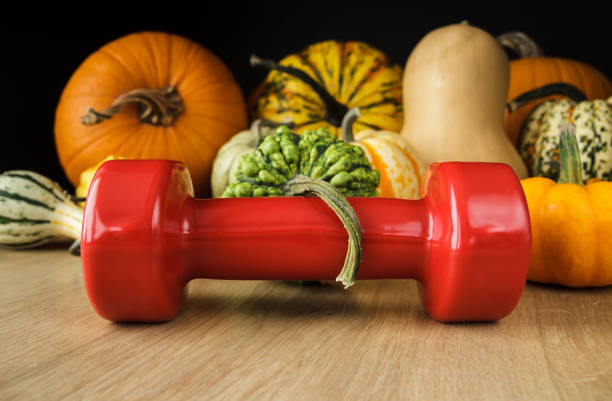 istock Autumn or fall composition, with gym dumbbell and various kinds of pumpkins. 1423524585