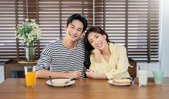 Portrait of happy asian loving couple enjoy eating breakfast in a cafe hotel or dining table. Modern family love dating healthy food lifestyle holiday concept