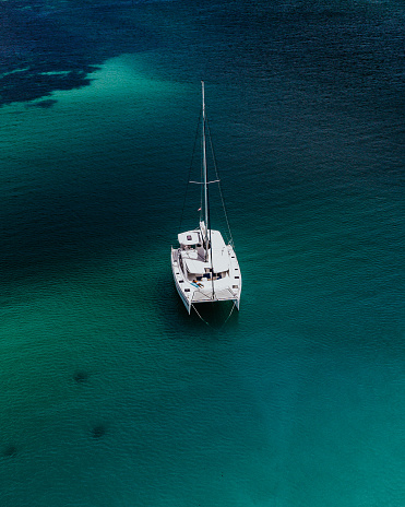 View from above, stunning aerial view of a catamaran sailing on a blue water in Mahé Island, Seychelles