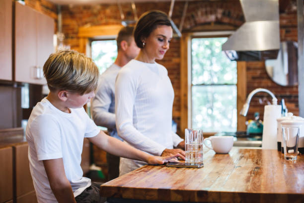 istock Boy reading a recipe while his parents are looking for ingredients to make dinner 1423527872