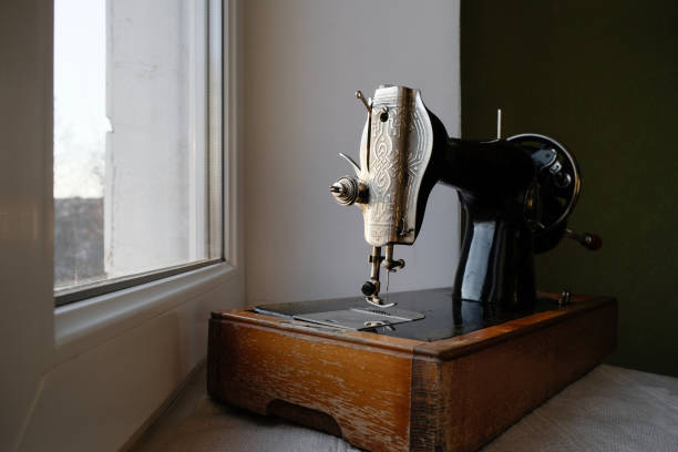 istock Vintage manual sewing machine 1960 on the room windowsill. 1423530102