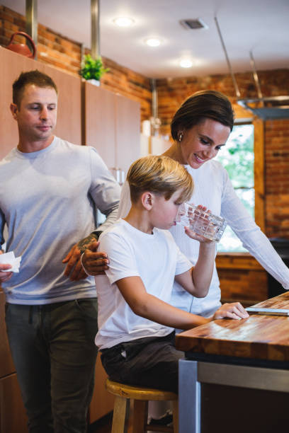 istock Mother embracing her son while is drinking a glass of water 1423530209