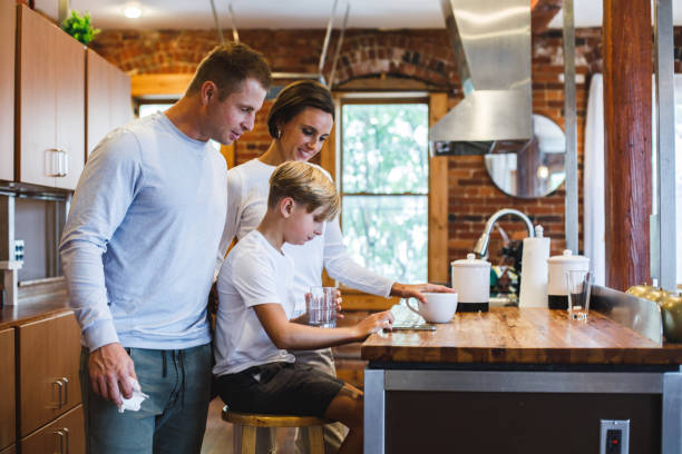 istock Boy showing memes to his parents while hanging out in the kitchen 1423530218