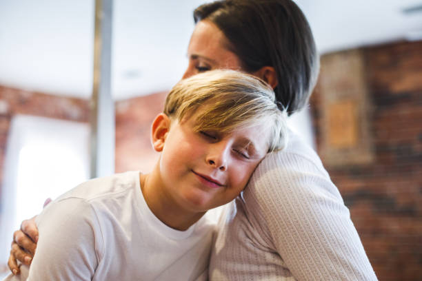 istock Boy enjoying his loving mother's affection, resting his head on her shoulder, eyes closed, smiling 1423530239
