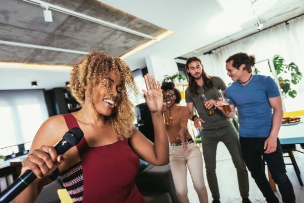 istock Group of young multicultural friends having party singing song using microphone at home. 1423530360