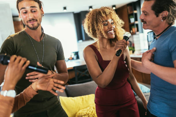 istock Group of young multicultural friends having party singing song using microphone at home. 1423530503