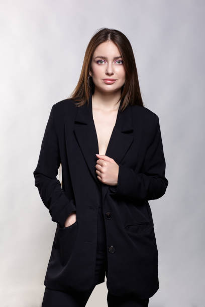 istock Woman in a black jacket on a gray background. 1423531375