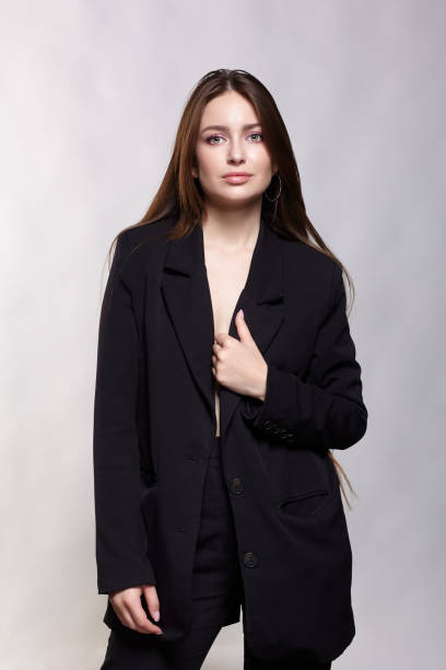 istock Woman in a black jacket on a gray background. 1423531389