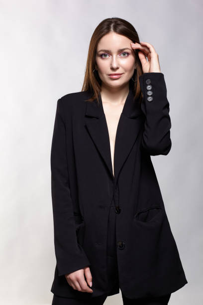 istock Woman in a black jacket on a gray background. 1423531635