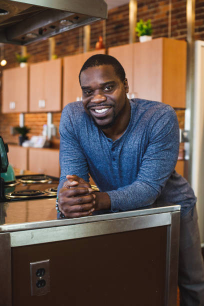 istock Happy mid adult man standing in his kitchen, joyfully smiling at camera 1423533298