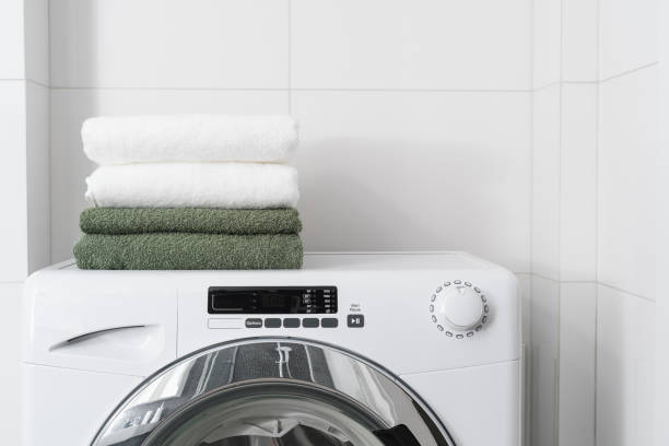 clean terry towels on washing machine indoors stock photo