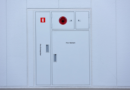 Fire extinguishers cabinet of public facility.\nIndustrial safety concept.