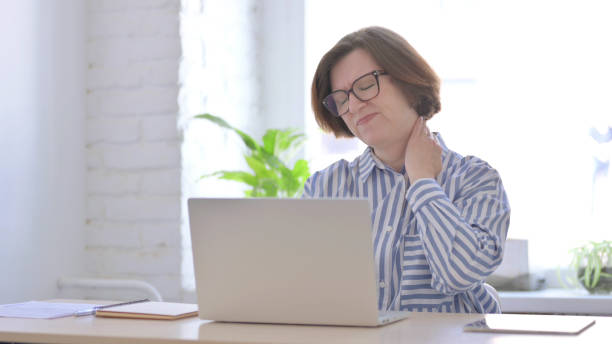 istock Senior Woman having Neck Pain while using Laptop 1423535371