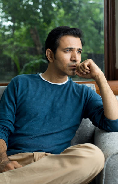 istock Thoughtful man sitting at home 1423537188