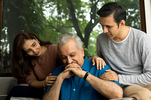 Couple comforting and giving moral support to senior man suffering with depression