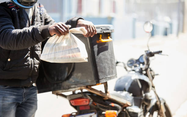 istock Delivery guy with medicine parcel standing by his motorcycle outside 1423538927